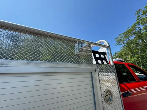 Long upper side compartment interior close-up with smooth metal walls.